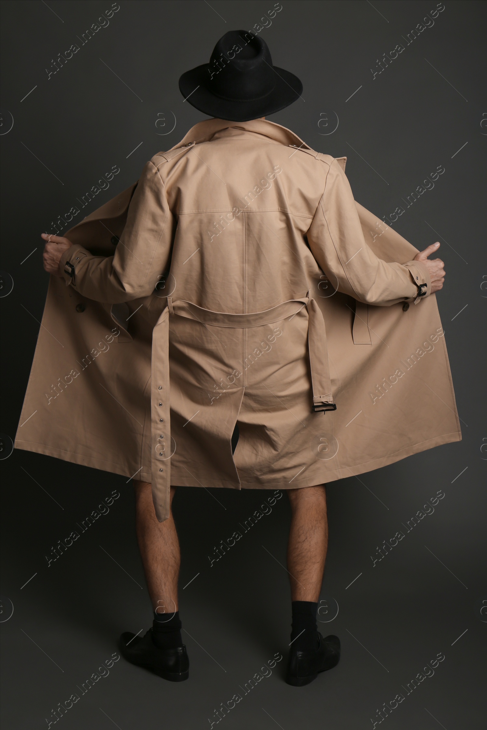 Exhibitionist Exposing Naked Body Under Coat On Black Background Back