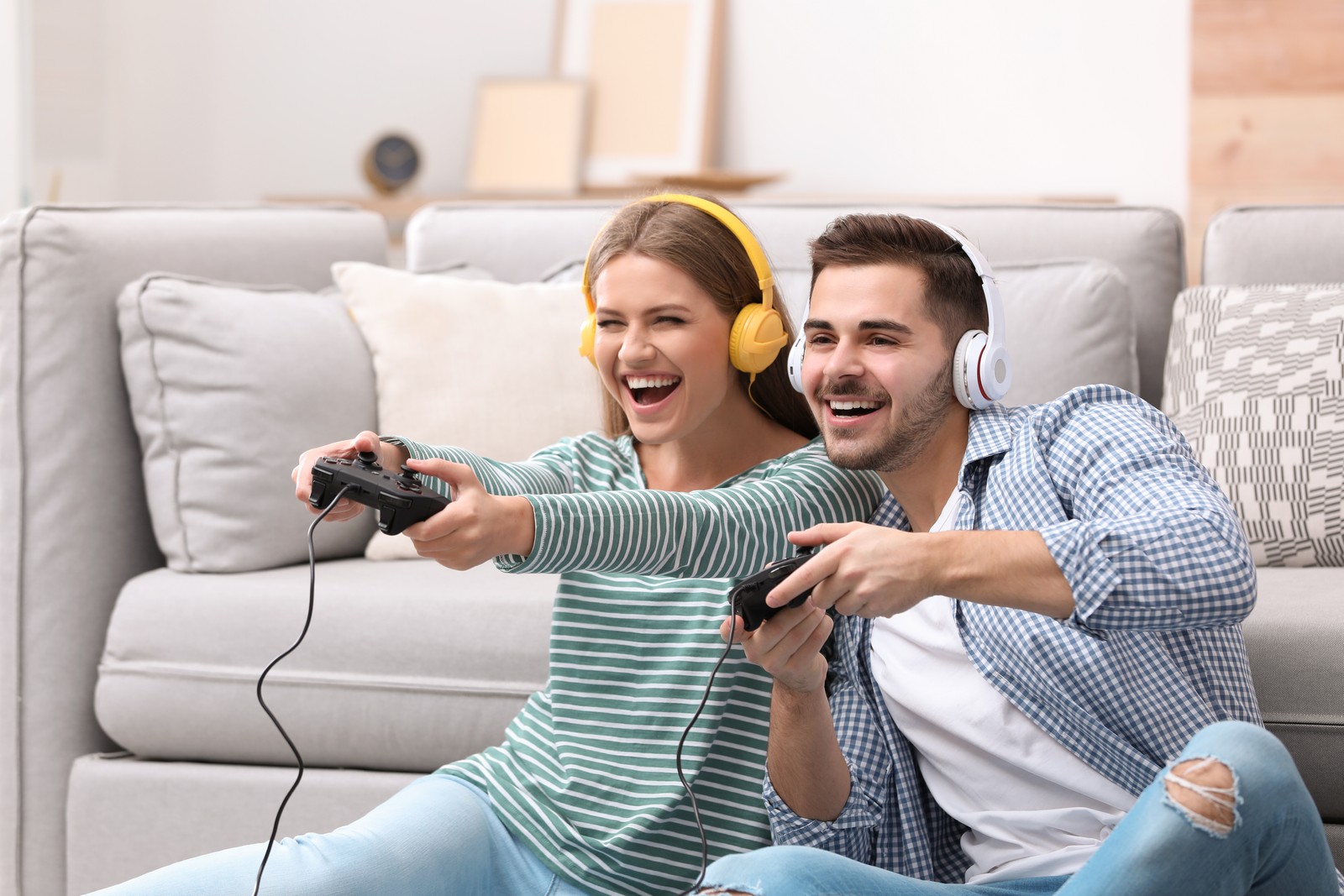 Photo of emotional young couple playing video games at home