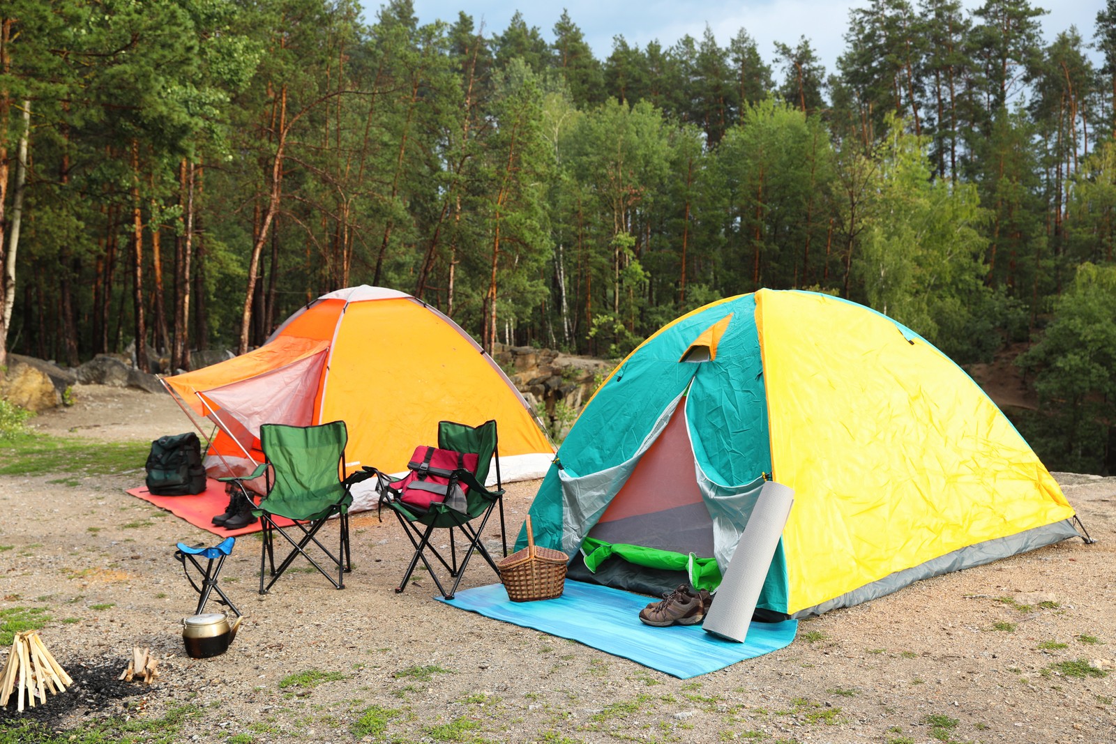 Photo of camping tents and accessories in wilderness on summer day
