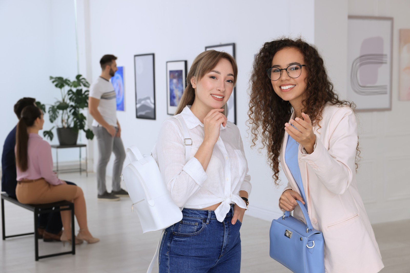 Photo of young women at exhibition in art gallery