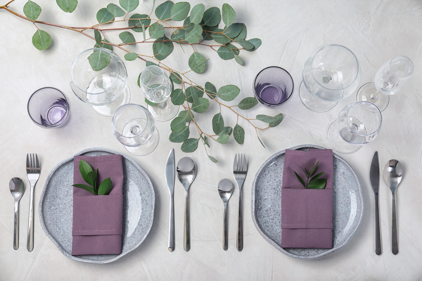 Photo of festive table setting with plates, cutlery and napkins on light background, flat lay