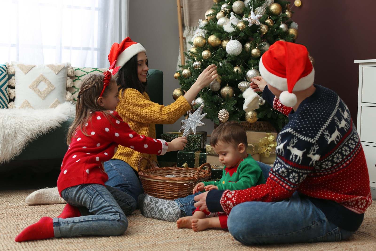 Photo of family decorating beautiful Christmas tree at home