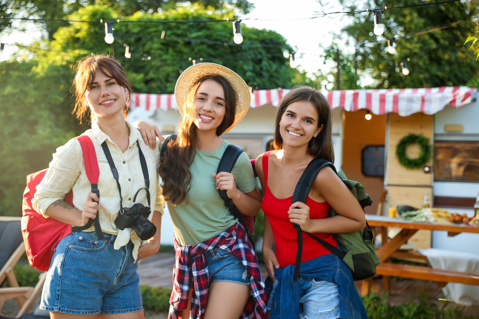 Photo of young travelers with backpacks and camera outdoors. Summer trip