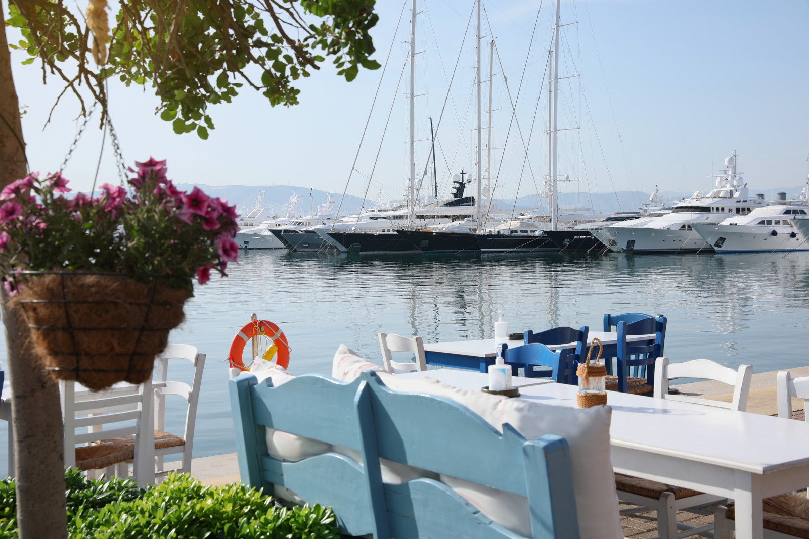 Photo of beautiful view of outdoor cafe with tables near pier