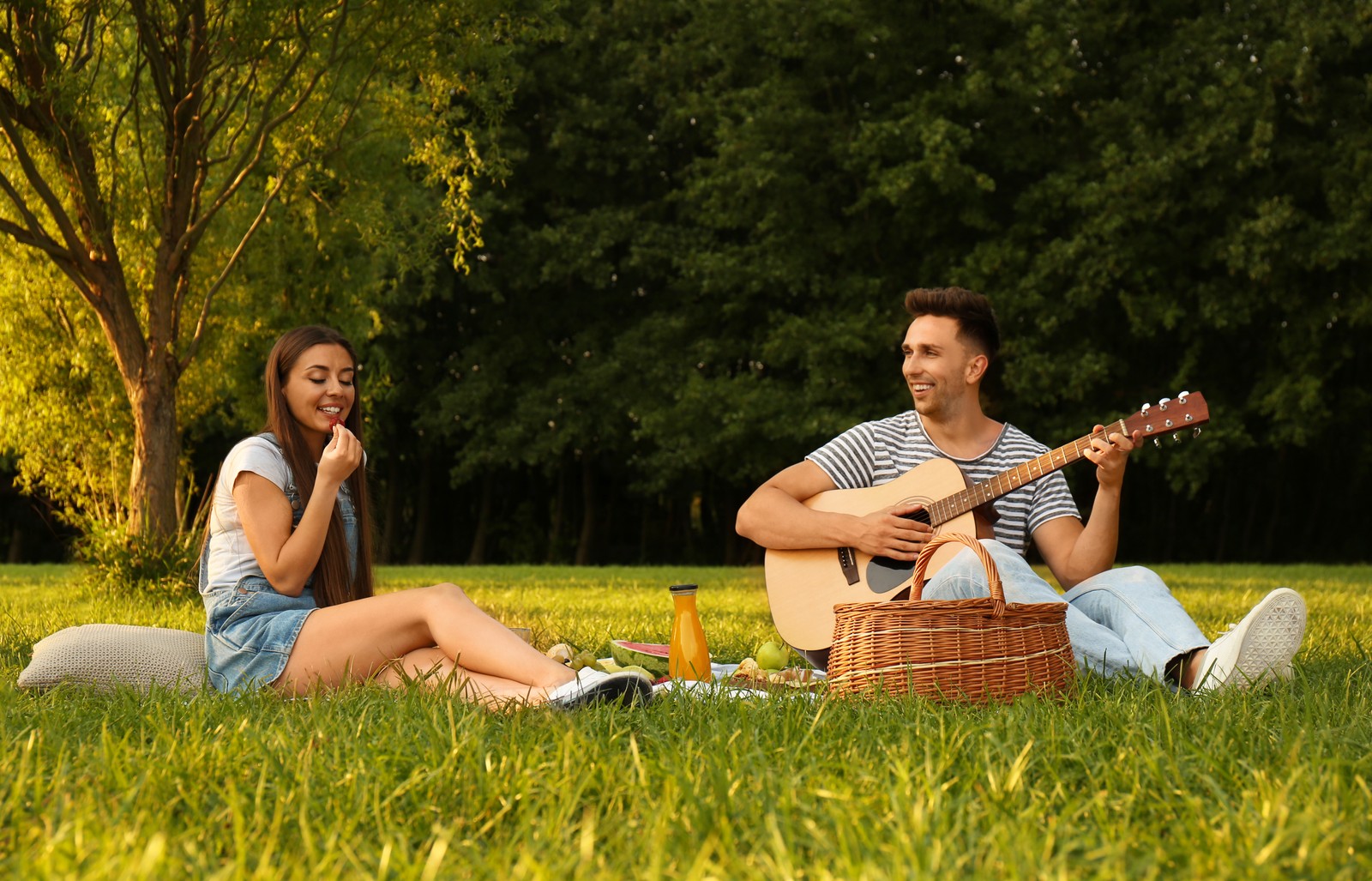 Photo of happy couple having picnic in park on sunny day