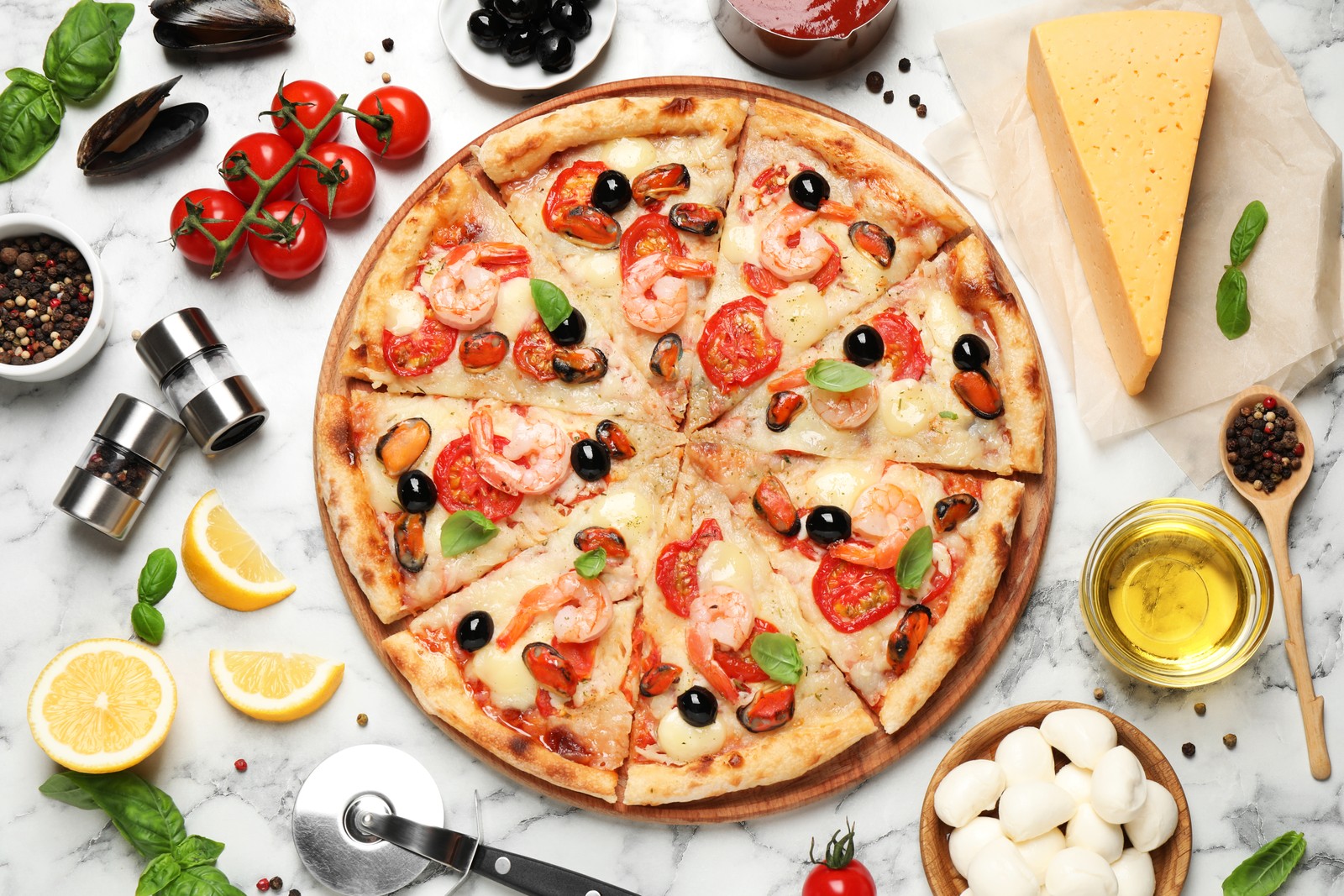 Photo of tasty pizza with seafood and ingredients on white marble table, flat lay