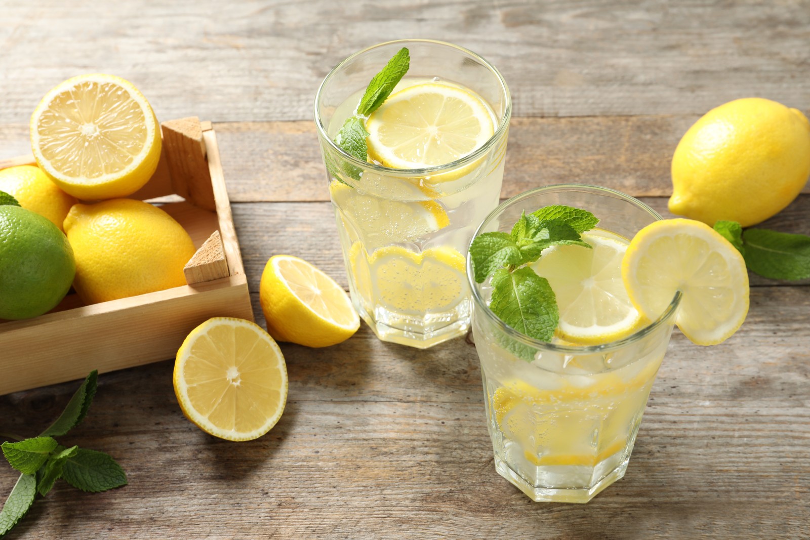 Photo of glasses of natural lemonade with mint on table