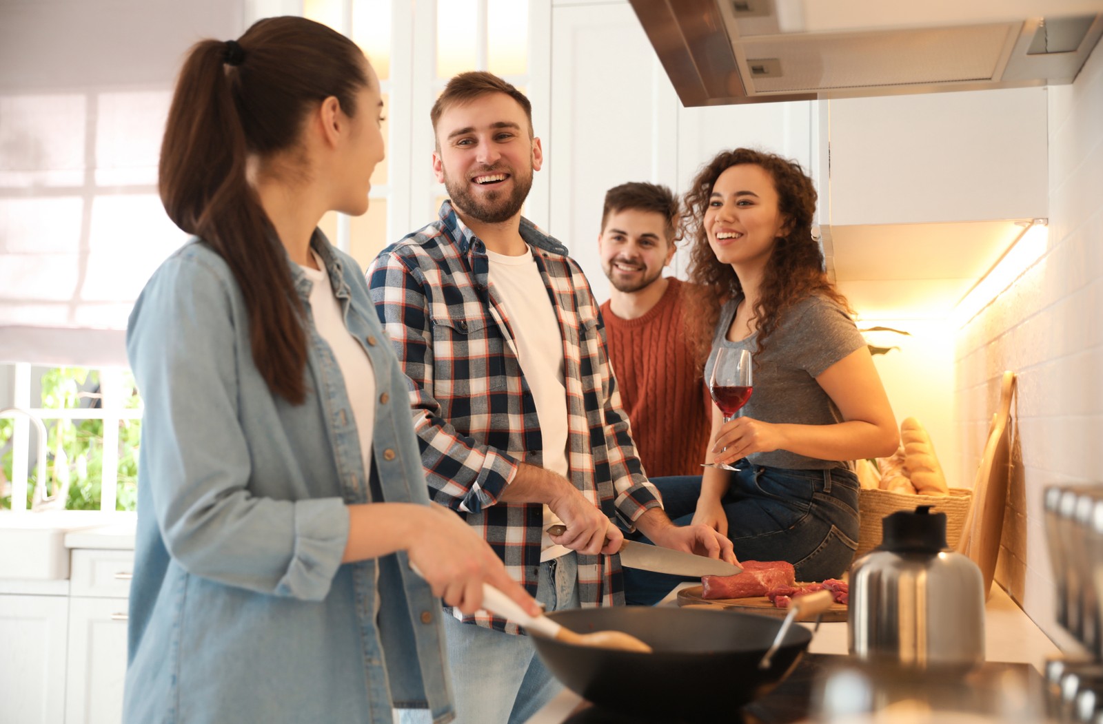 Photo of happy people cooking food together in kitchen