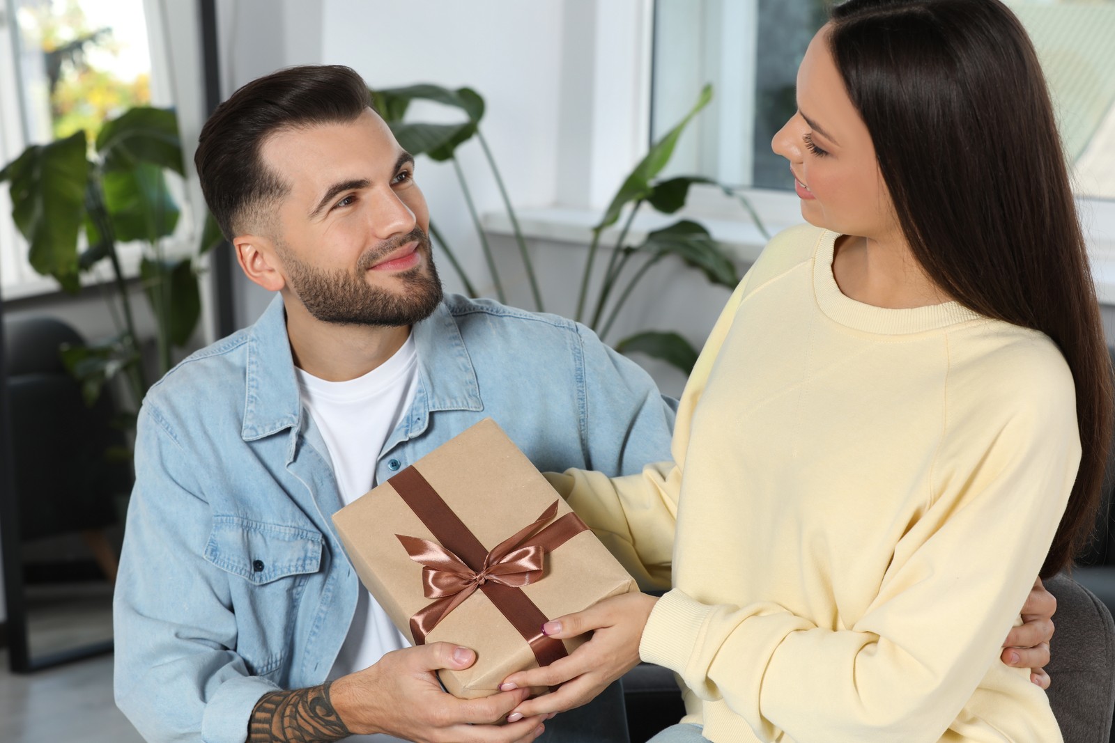 Photo of lovely couple with beautiful gift at home