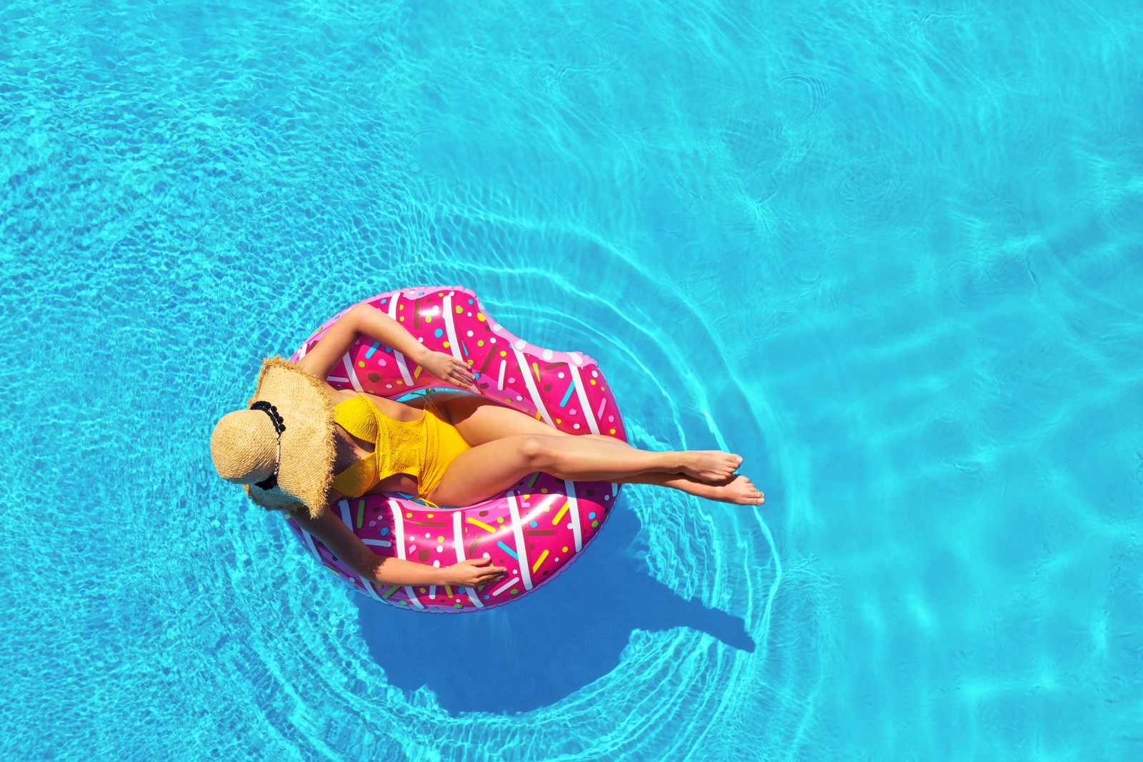 Photo of young woman with inflatable ring in swimming pool, top view