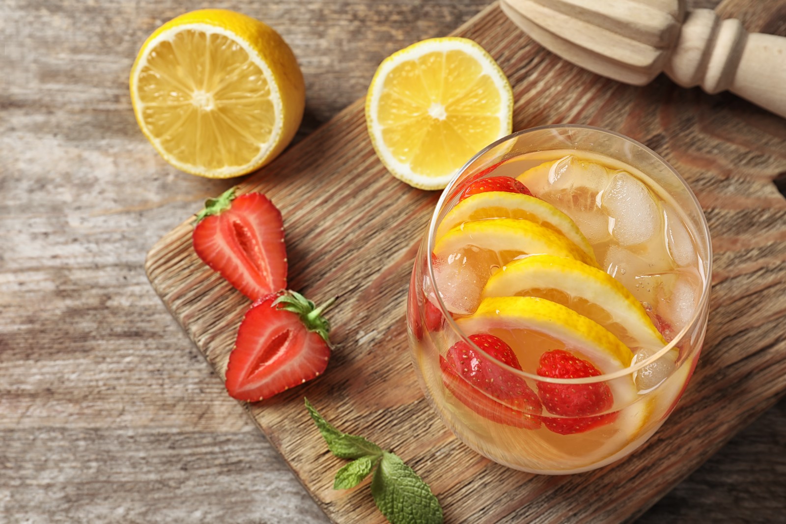 Photo of natural lemonade with strawberries in glass on table