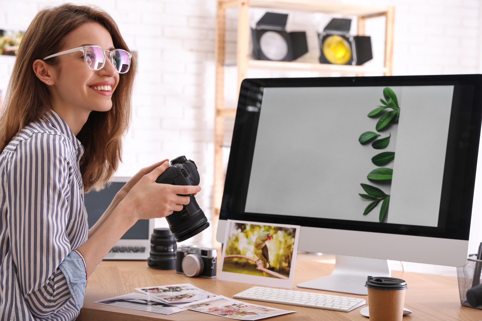 Photo of professional photographer with camera working at table in office