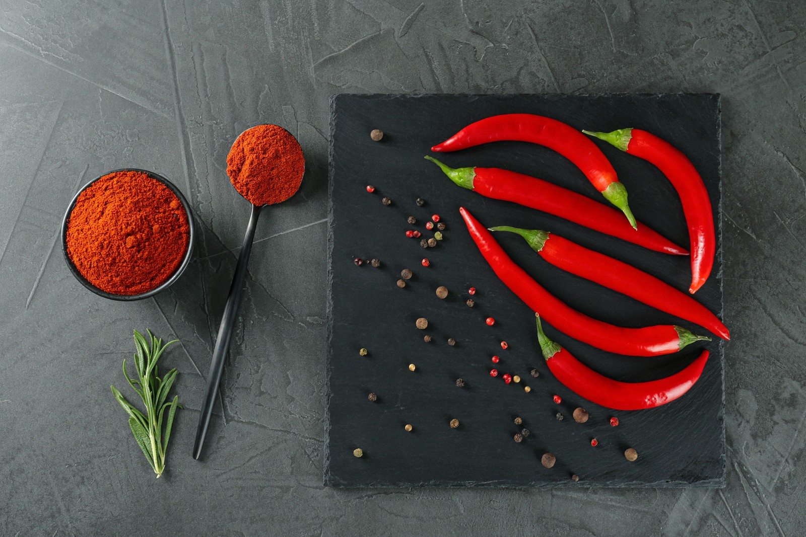 Free photo of ground red pepper and ingredients on grey table, flat lay
