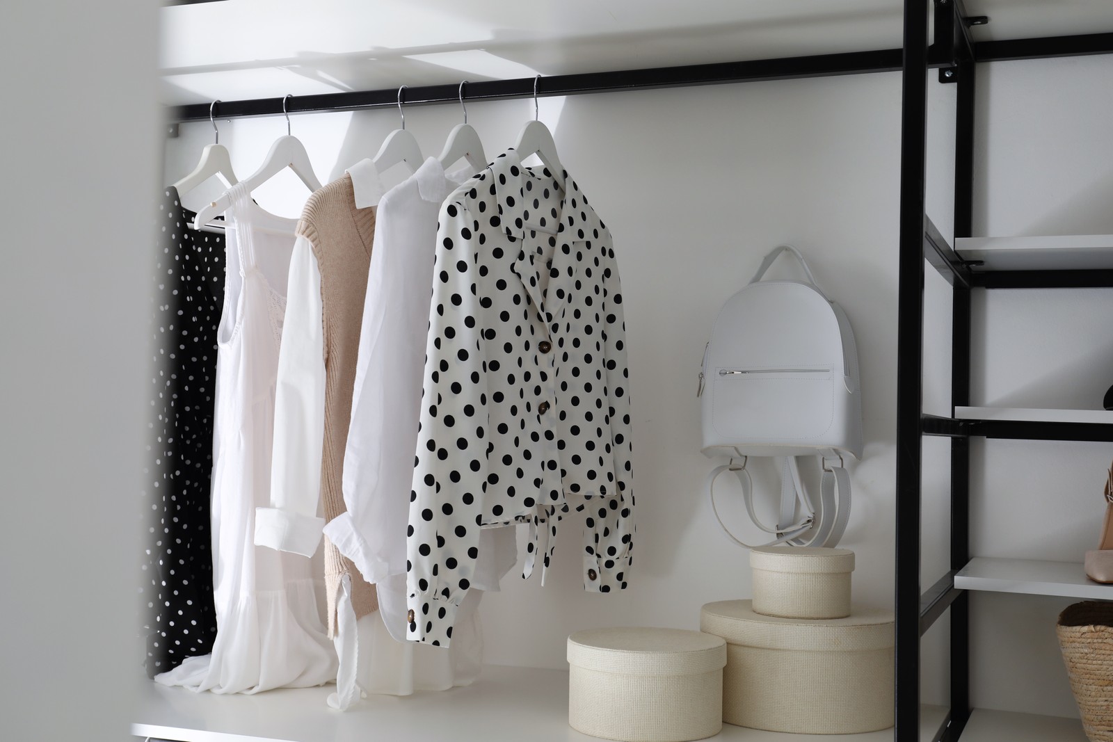 Photo of storage rack with stylish women's clothes and accessories indoors