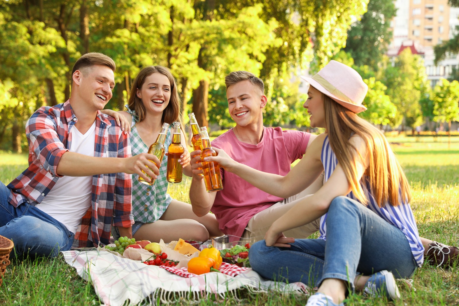Photo of young people enjoying picnic in park on summer day