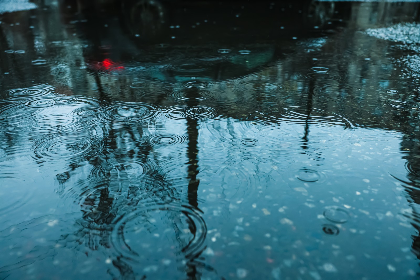 Free photo of rain drops falling down onto puddle outdoors