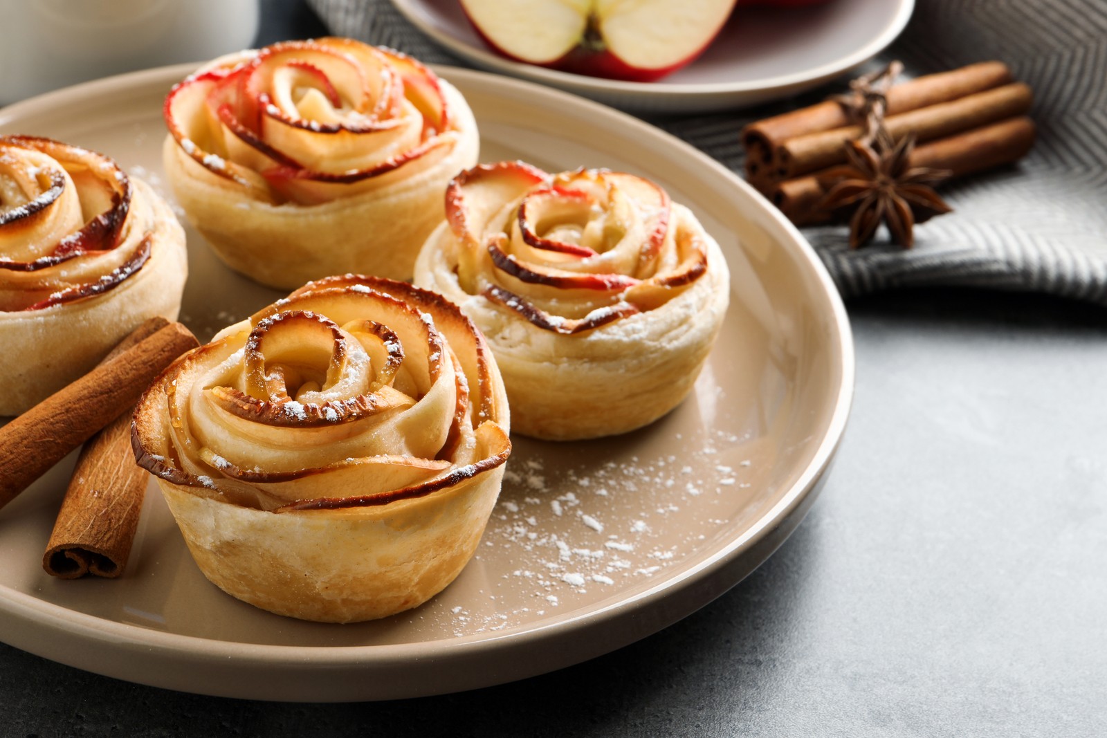 Photo of freshly baked apple roses on grey table. Beautiful dessert