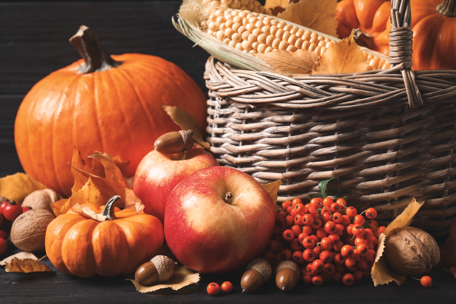 Photo of composition with vegetables, fruits and autumn leaves on black wooden table. Thanksgiving Day