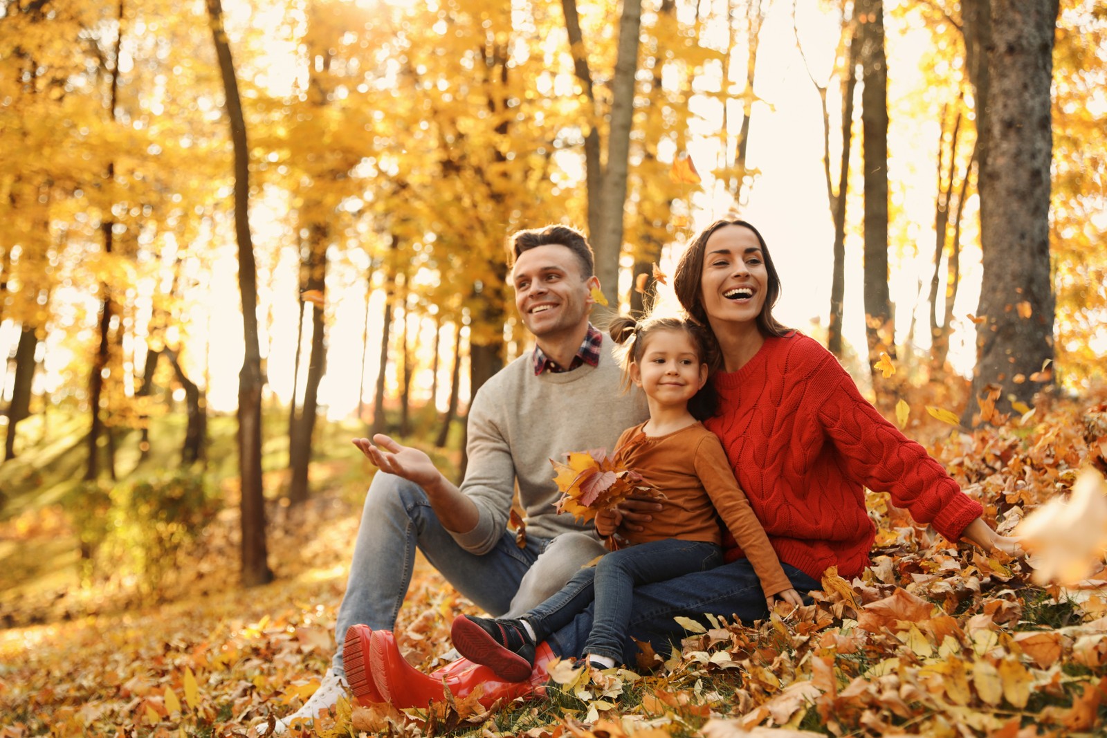 Photo of happy family with little daughter in park. Autumn walk