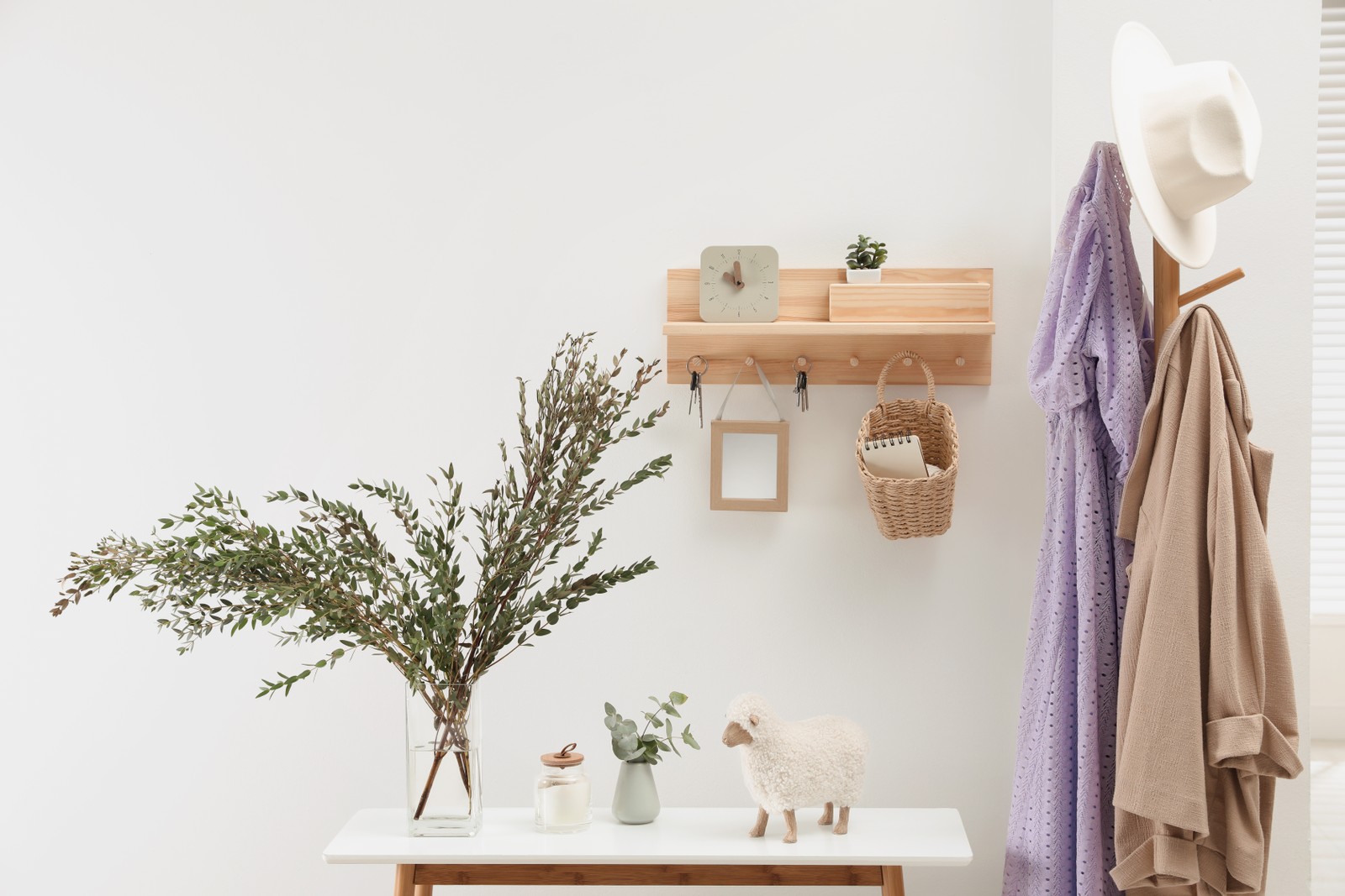 Photo of wooden clothes rack and key holder on white wall in hallway