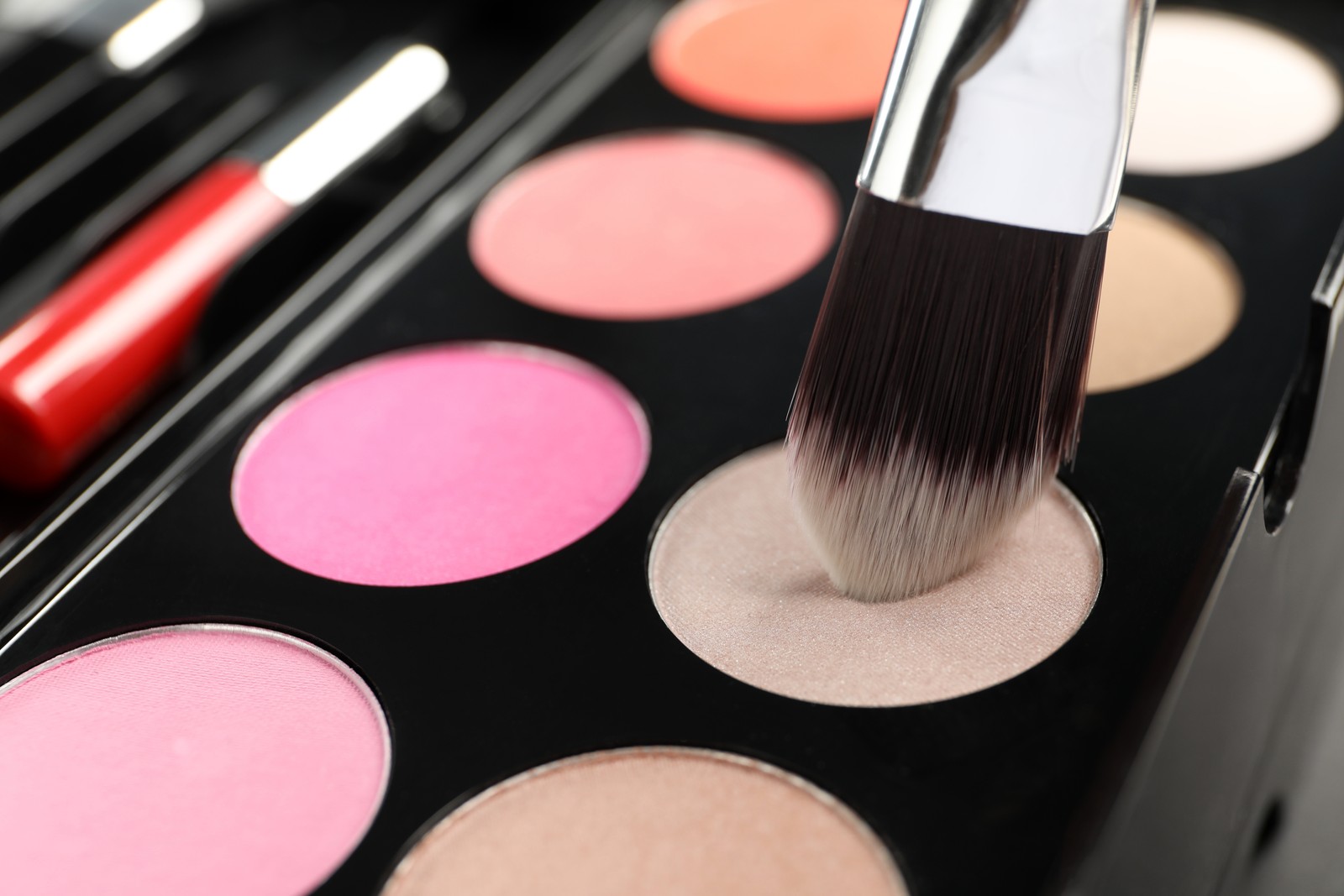 Photo of colorful eyeshadow palette with brush, closeup view