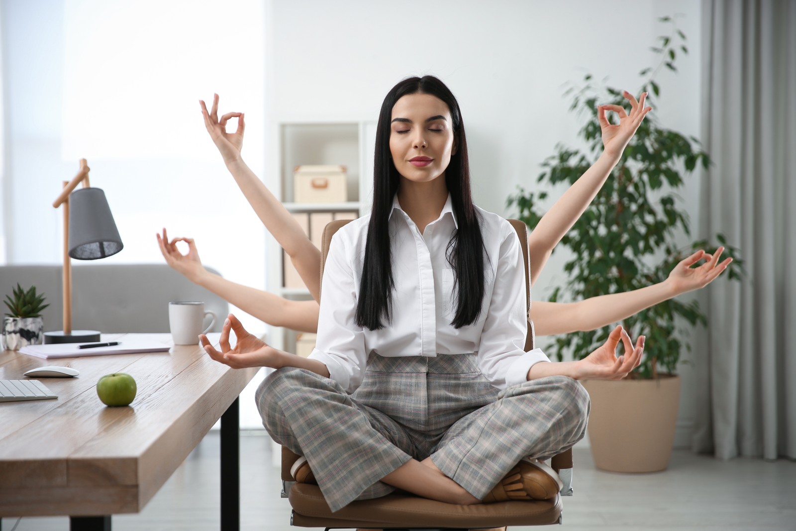 Photo of young woman meditating at workplace. Stress relief exercise