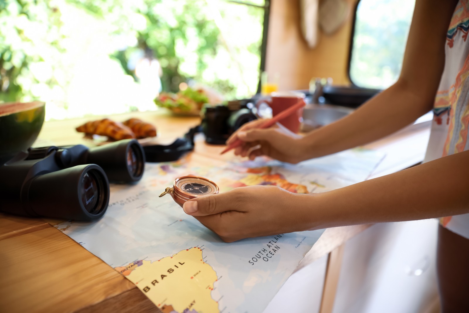 Photo of young traveler with world map planning trip in motorhome, closeup