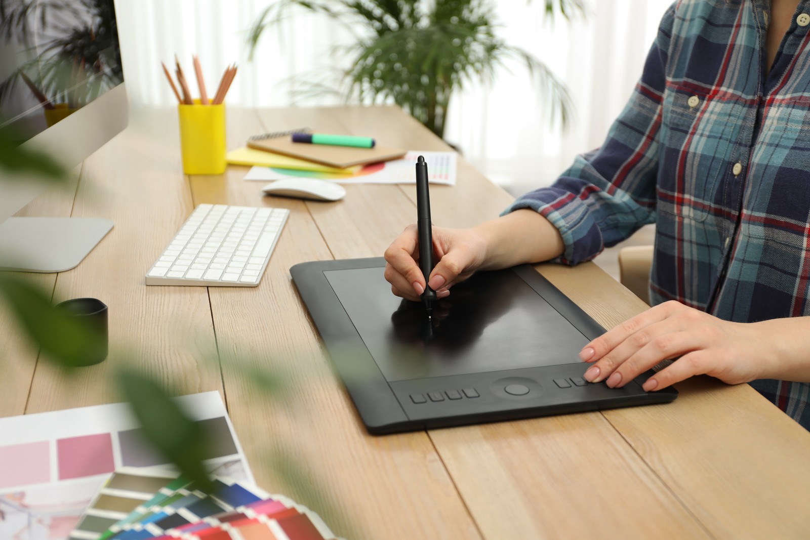 Photo of professional designer working on graphic tablet at desk, closeup