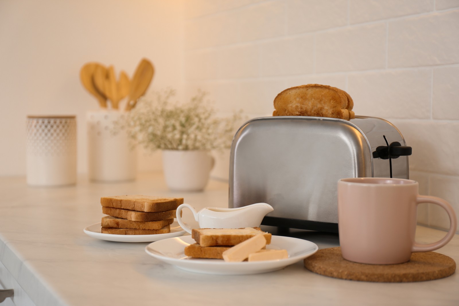 Photo of modern toaster and tasty breakfast on counter in kitchen