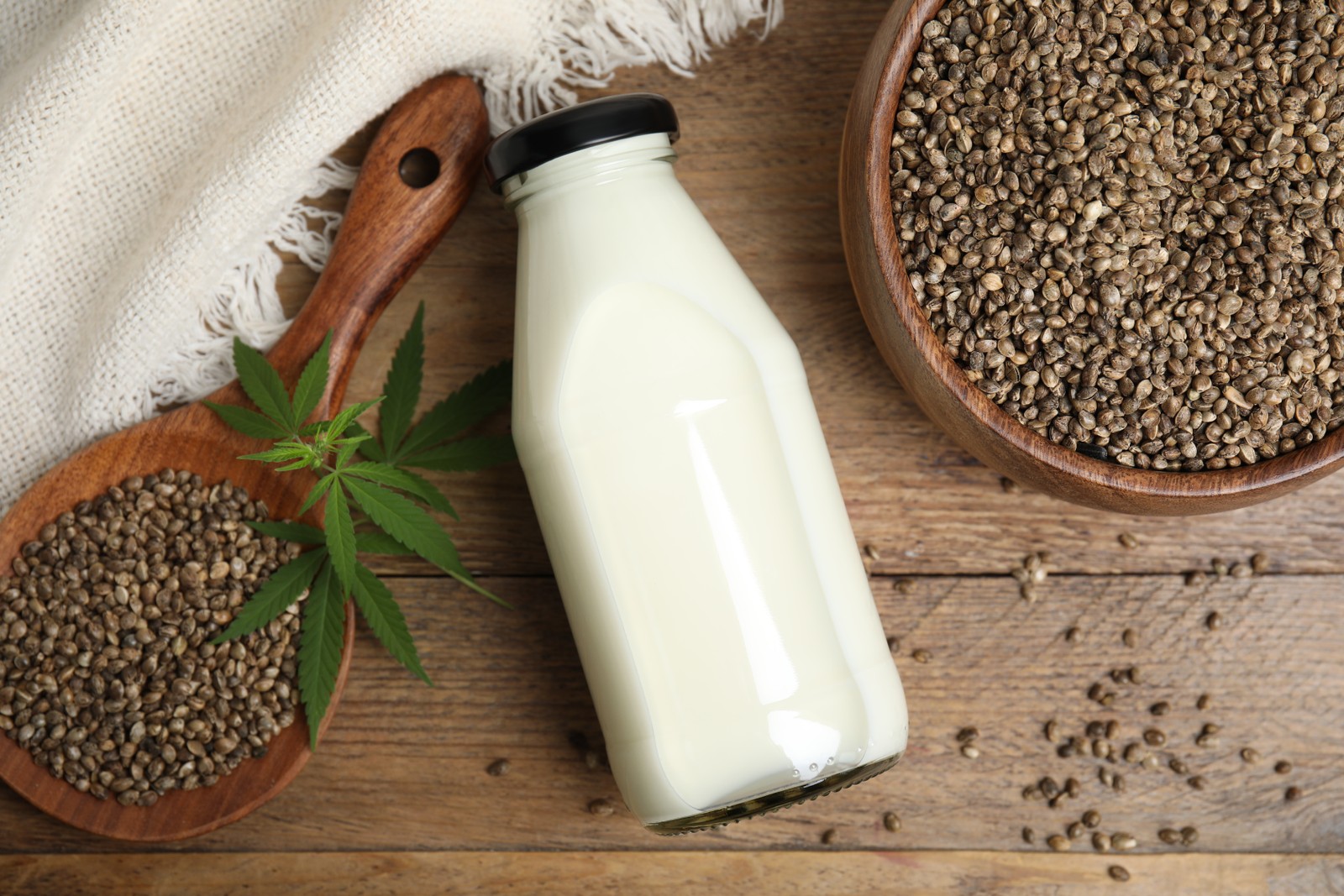 Photo of flat lay composition with fresh hemp milk on wooden table