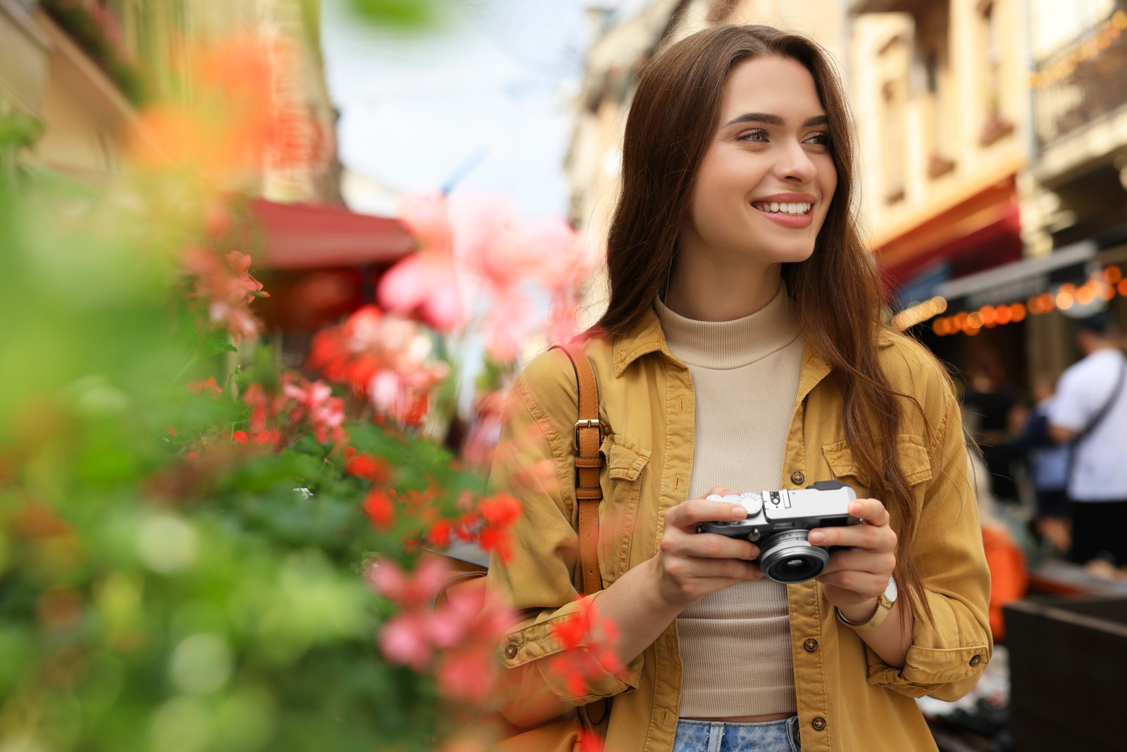 Photo of young woman with camera on city street. Interesting hobby