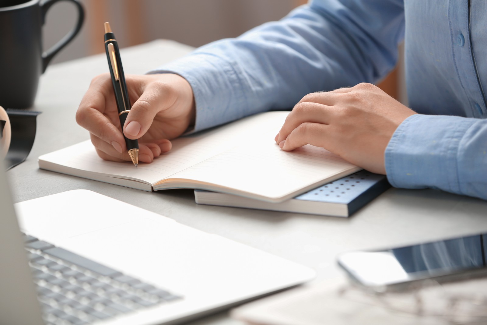 Photo of journalist working at table in office, closeup