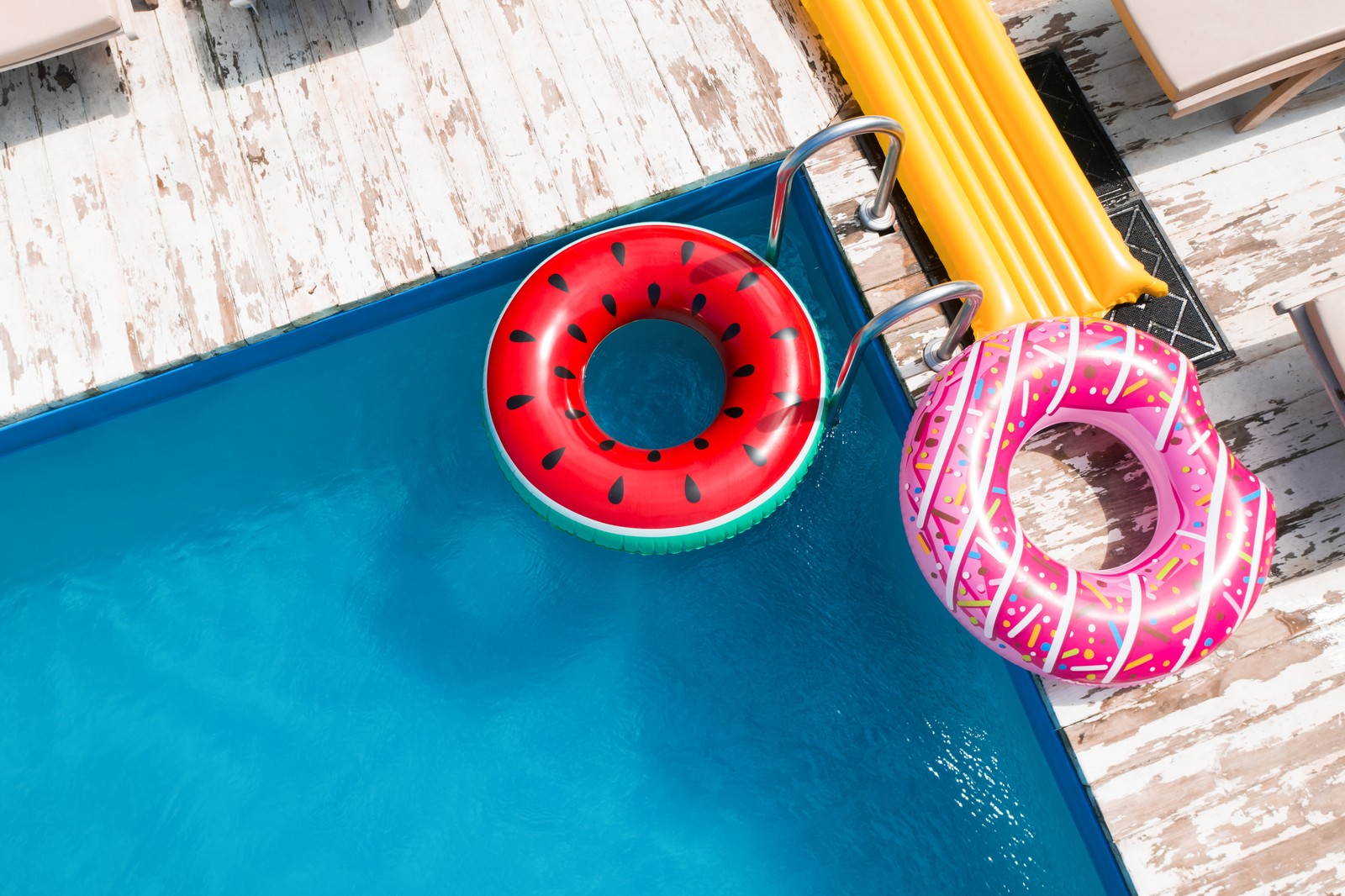 Photo of above view of inflatable rings and swimming pool. Summer vacation